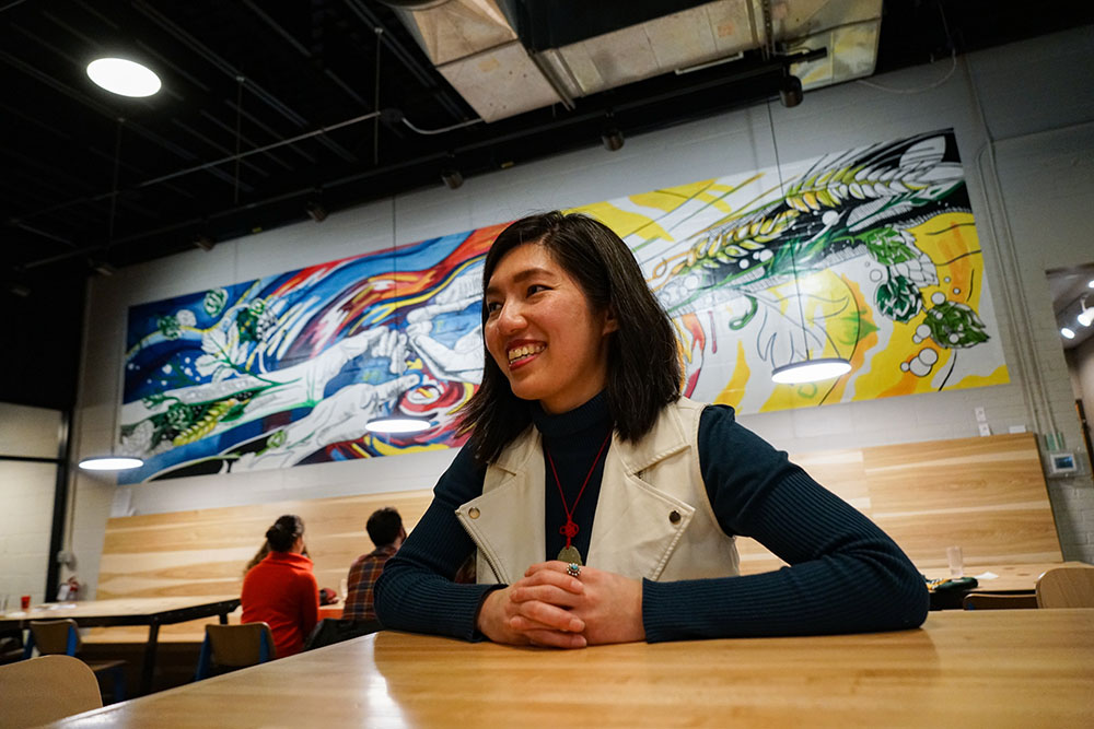 Mural Artist, Jenie Gao, with Craft Brewery Mural Behind Her