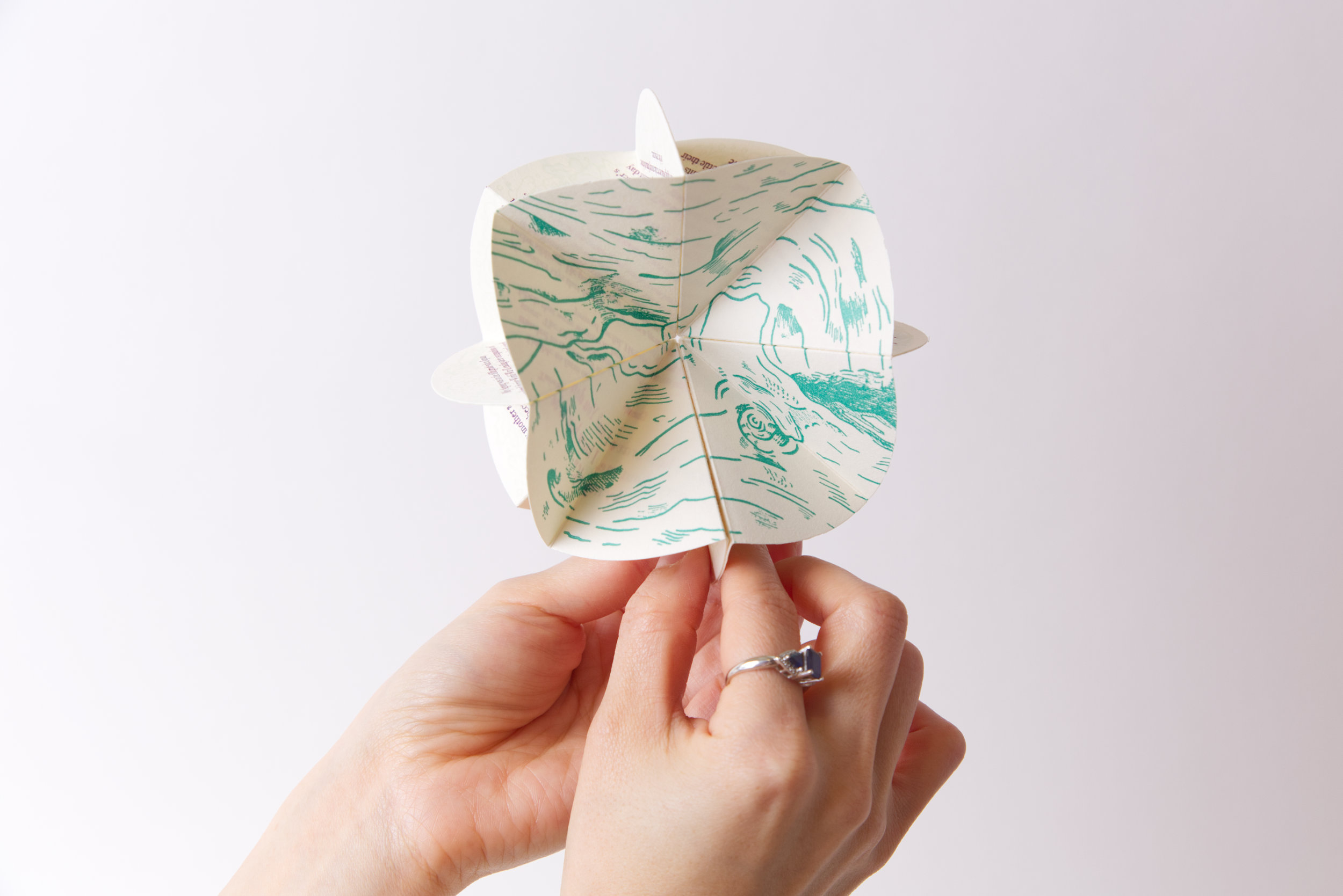 Gao holding artist's book, opening one page spread to a full circle